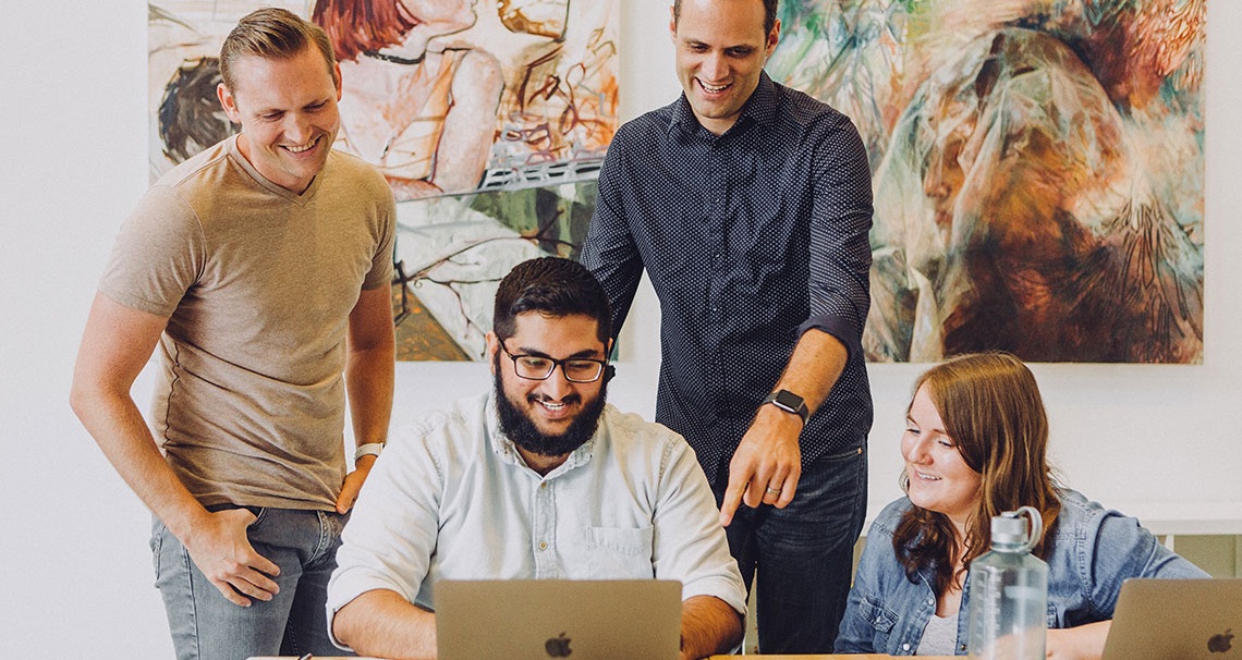 Stellenausschreibung Director M&A Immobilienwirtschaft – Team im Austausch am Laptop