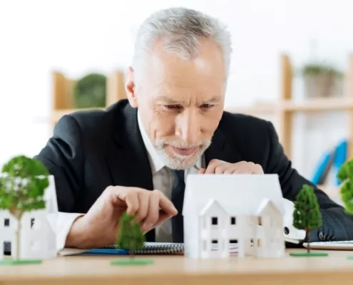 Hausverwalter prüft stolz ein Häusermodell