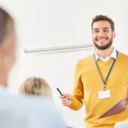 Fit für die Zukunft: Förderung für Weiterbildung in der Immobilienverwaltung - junger Dozent steht vor einer Gruppe Lernender