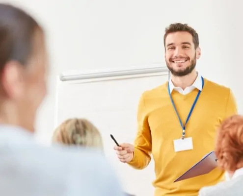 Fit für die Zukunft: Förderung für Weiterbildung in der Immobilienverwaltung - junger Dozent steht vor einer Gruppe Lernender